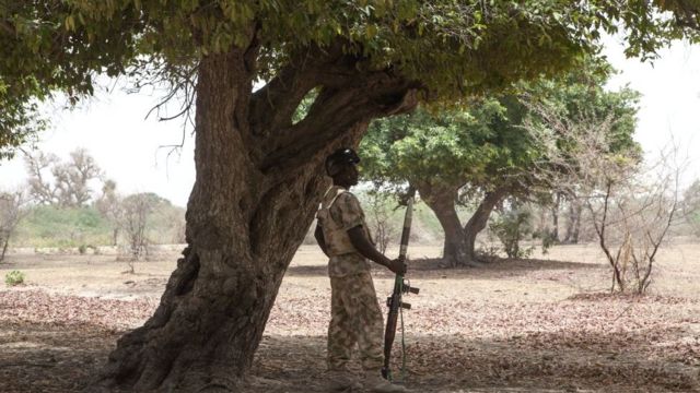 جندي بقذيفة صاروخية (آر بي جي) يقف في حراسة تحت شجرة في بورنو ، نيجيريا - 2017