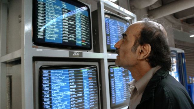 Mehran Karimi Nasseri mira los monitores con los vuelos en 2004