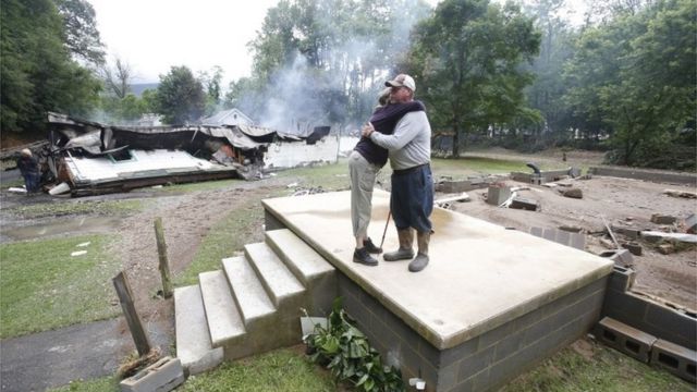 Jimmy Scott gets a hug from Anna May Watson, left, as they clean up from severe flooding in West Virginia.