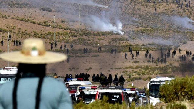 Policías y civiles enfrentándose.