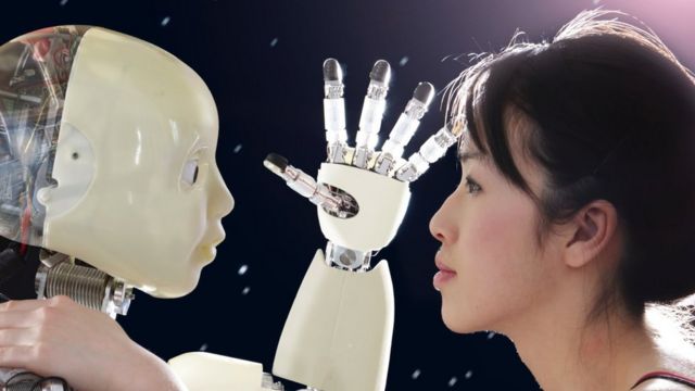 A humanoid robot holds a hand in front of a woman who is looking into its eyes with her hand on its shoulder