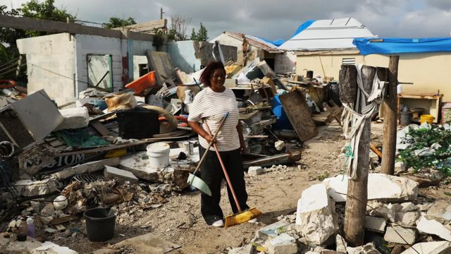 Mulher em meio a escombros em Barbuda