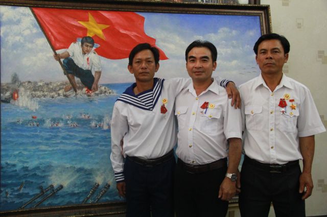 Chú thích: Các cựu tù binh Trương Văn Hiền, Lê Minh Thoa và Lê Văn Đông trong một lần tái ngộ ở Sài Gòn bên bức tranh Gạc Ma - Vòng tròn bất tử.