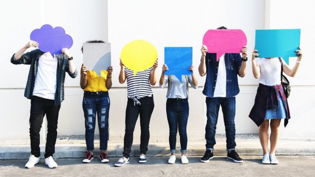 Seis pessoas seguram imagens coloridas de balões de diálogo