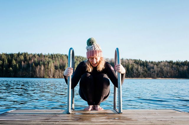 Chica tratando de meterse en un lago helado en Suecia