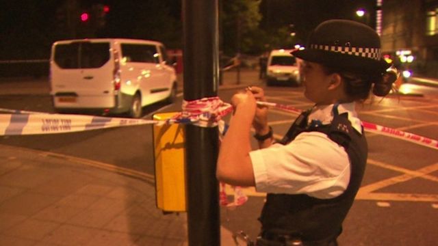 立ち入り禁止のテープを張る警官