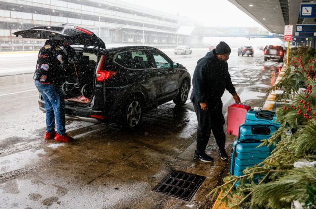 Una persona llega al aeropuerto en medio de la tormenta de nieve