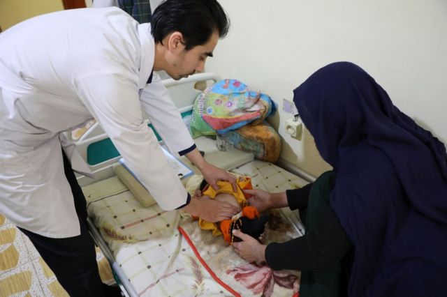 Un médico afgano atendiendo a un niño.