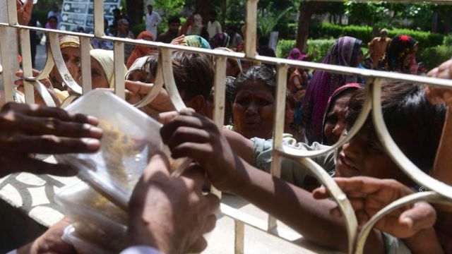 Беженцы дерутся, чтобы получить коробку с едой от правительственного чиновника в Суккуре, провинция Синд, 29 августа 2022