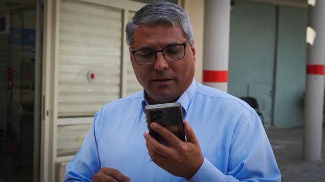 اعطا ابو مدیغم شهردار رهط به موبایلش نگاه می‌کند