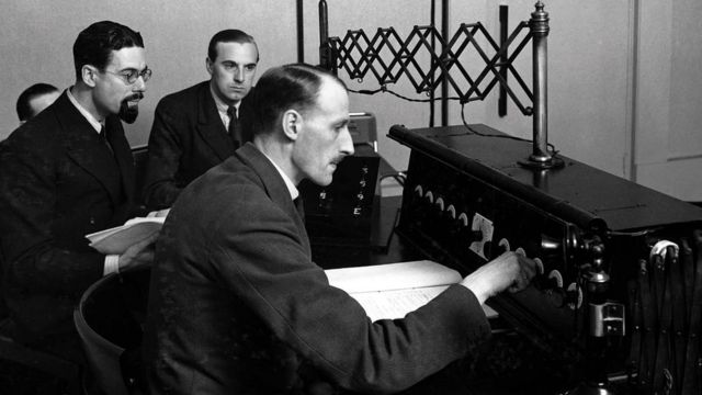 Técnicos sentados frente a una consola en la primera estación de radio de la BBC 2LO