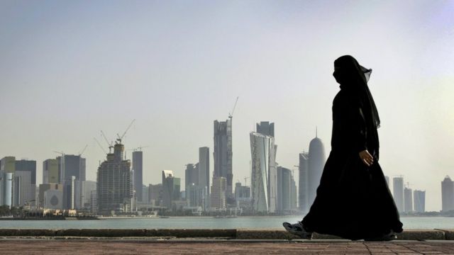 Mulher, vestida com burca, caminha em Doha