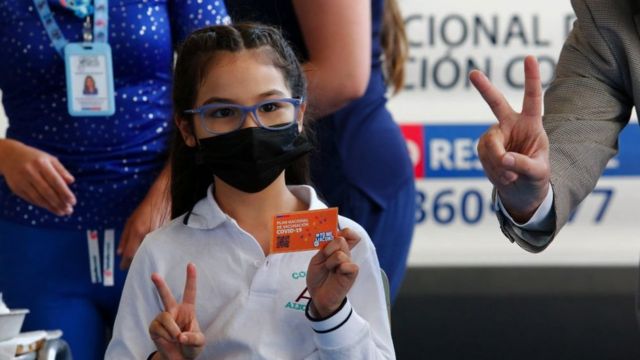 طالبة تحمل بطاقة التطعيم عند تلقي جرعة من لقاح سينوفاك ضد كورنا في مدرسة أليكانتي ديل روسال في 1 أكتوبر /تشرين الأول 2021 في سانتياغو، تشيلي.