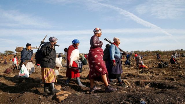 A group of women carrying pickaxes