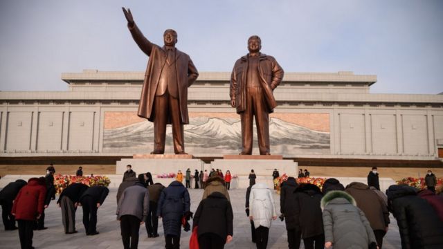 Người dân cúi đầu trước bức tượng của các cố lãnh đạo Triều Tiên Kim Nhật Thành và Kim Jong-il, tháng 2 năm 2021