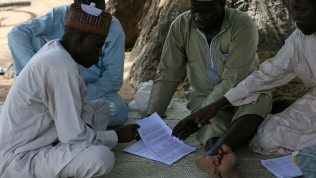 Parents of missing school girls check name lists in Dapchi. Photo: 23 February 2018