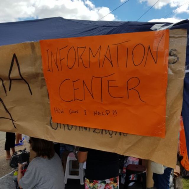Placa com os dizeres Information Center, How Can I Help (Centro de Informações, como posso ajudar)