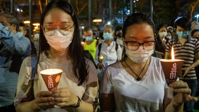 香港维多利亚公园两名手持烛光的女示威者为北京“六四”事件死难者默哀（4/6/2020）