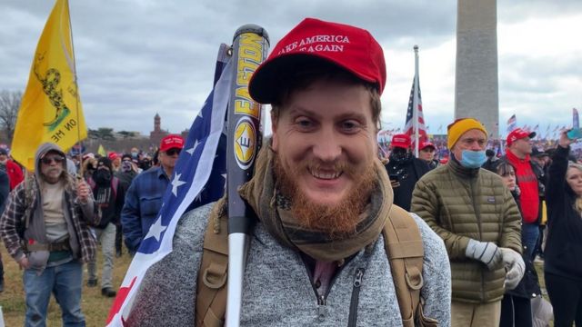 Apoiador de Trump empunha taco de beisebol com bandeira americana