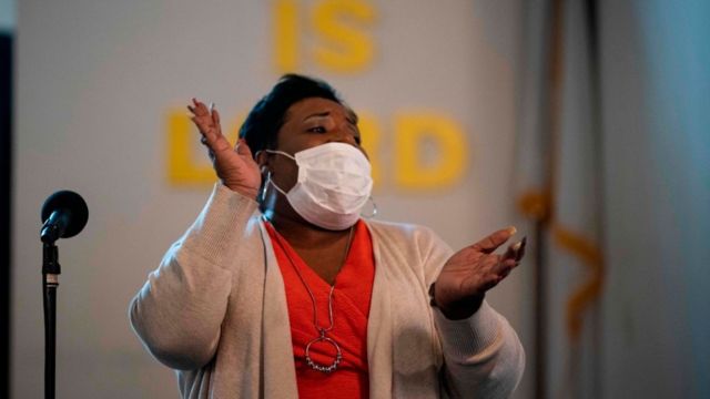 A woman sings and claps during Easter Sunday morning services at The Friendship Baptist Church on April 12, 2020 in Maryland