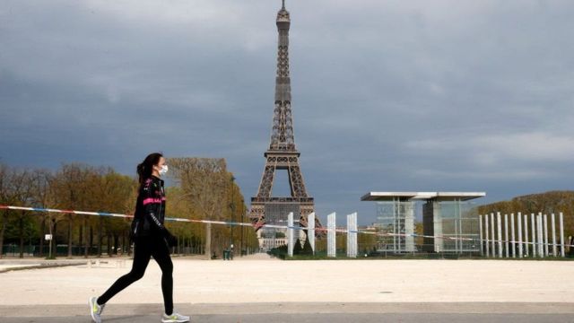 Mulher corre em frente a torre Eiffel