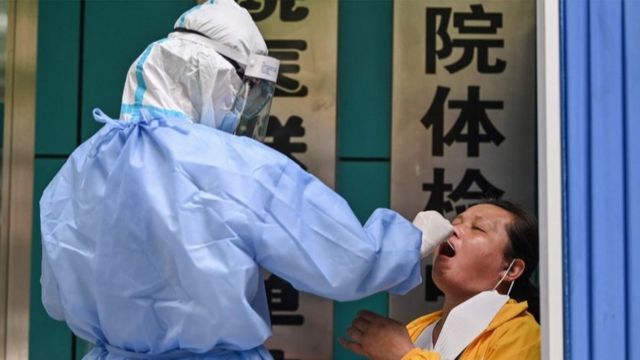 A medical worker takes a swab sample from a woman to be tested for the COVID-19 novel coronavirus in Wuhan, in Chinas central Hubei province on May 13, 2020.