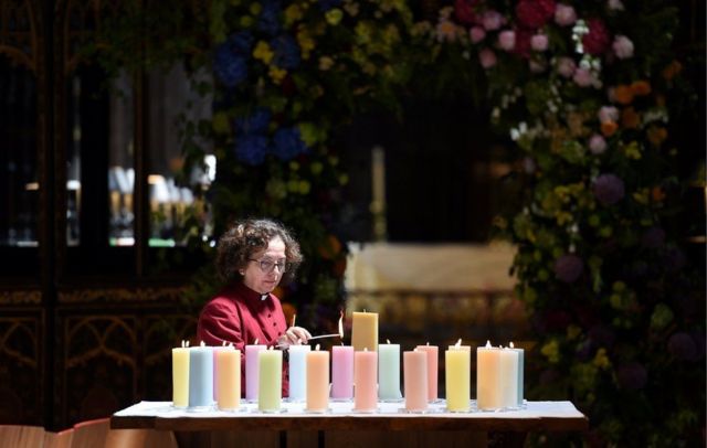 Seorang pendeta menyalakan lilin untuk korban serangan Manchester Arena di Inggris