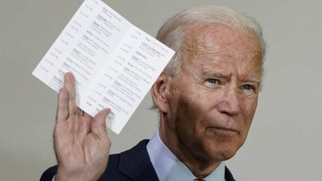 Joe Biden holds up a copy of his daily schedule, which includes statistics about how many U.S. troops have died while serving in Afghanistan and Iraq