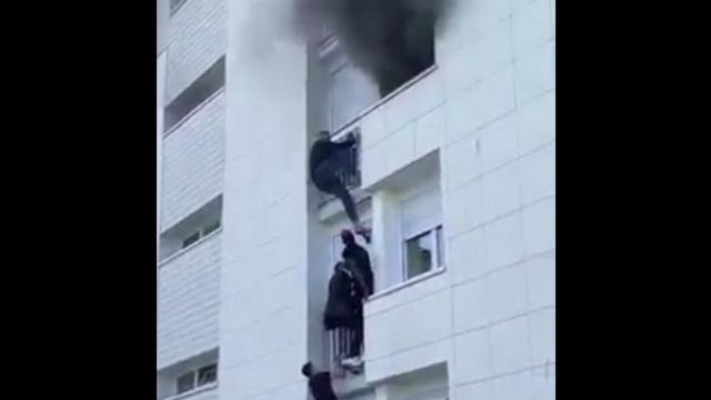 شباب يتسلقون المبني المشتعل