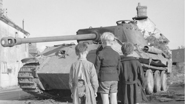 Niños frente a un tanque alemán en la derrota nazi en Francia