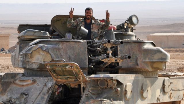 A soldier from the Syrian government forces flashes the "V" for victory sign in the eastern Syrian city of Deir Ezzor during an operation against Islamic State (IS) group jihadists on November 2, 2017.