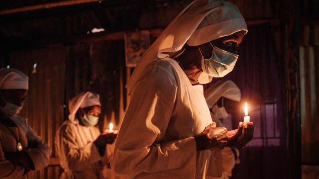 Worshippers of Legio Maria wearing face mask as a preventive measure against the spread of COVID-19 attend the Christmas prayer at their church in the Kibera slum of Nairobi, on December 25, 2020.