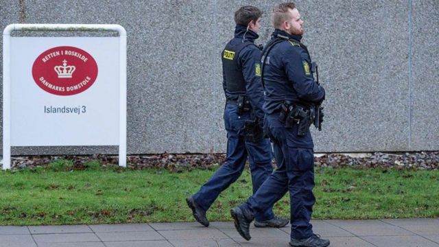 شرطيان مدججان بالسلاح يحرسان محيط المحكمة في الدنمارك.