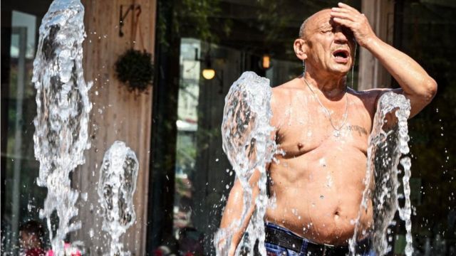 Hombre refrescándose en una fuente en Moscú