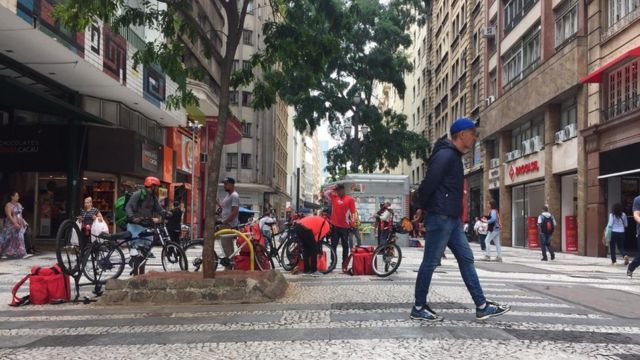 Na Barão de Itapetininga, entregadores de aplicativos esperam pedidos em frente a redes de fast food