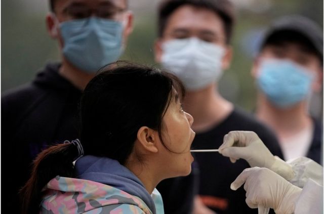 A woman is tested for the new coronavirus at a nucleic acid testing site in Shanghai
