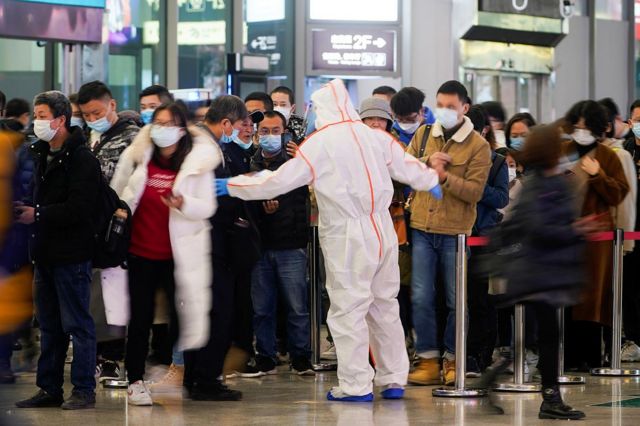 A security inspector at Shanghai Hongqiao Railway Station instructed people to scan the health code.