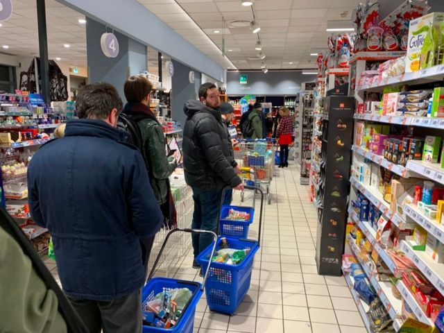 People queue to buy food in Milan as quarantine measures are announced