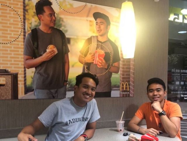 Jevh e Christian ao lado do pôster que fabricaram e penduraram no McDonald's