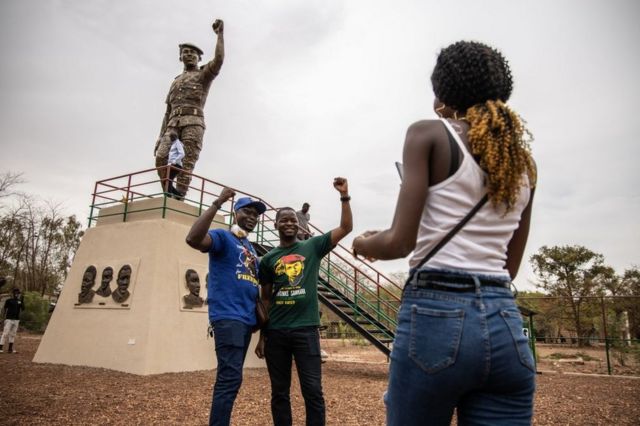 People pose for photos with the second bronze statue of Burkina Faso's former President Thomas Sankara on 17 May 2020.