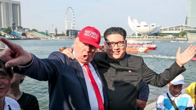 US President Donald Trump impersonator Dennis (L) and North Korean leader Kim Jong-un impersonator Howard (C-R) pictured against the Singapore Flyer and Marina Bay as they pose for photographers in Singapore, 08 June 2018