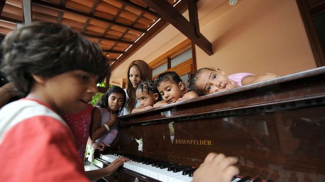 Flordelis con varios de sus hijos tocando el piano.