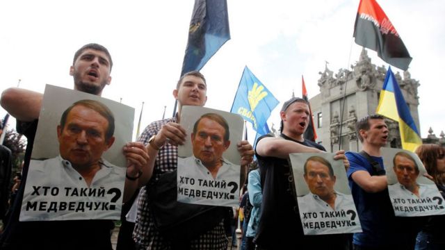 Miembros del partido de extrema derecha ucraniano Cuerpo Nacional sostienen pancartas con una de Medvedchuk. La imagen es de 2019