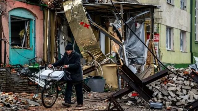 An old man pushes his bicycle in Bakhmut