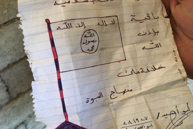 ورقة عثر عليها في أحد المنازل تصور العلم الذي يستخدمه مسلحو تنظيم الدولة الإسلامية