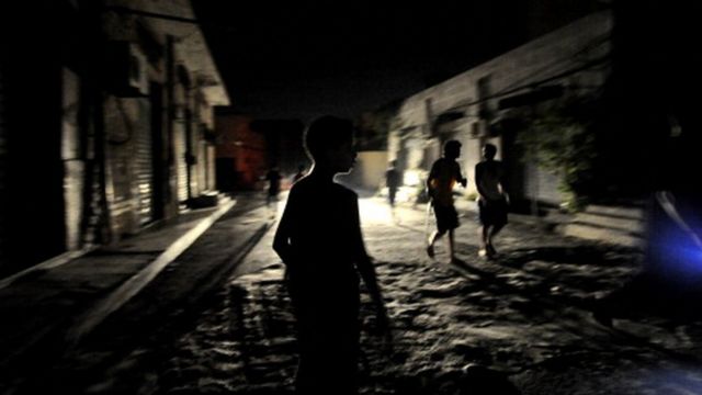 Des enfants circulant dans une rue sombre de Tripoli (archives)