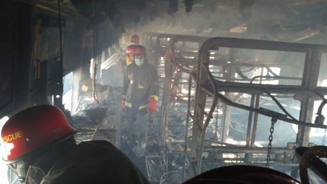 Petugas pemadam kebakaran Pakistan memeriksa kereta yang terbakar 31 Oktober