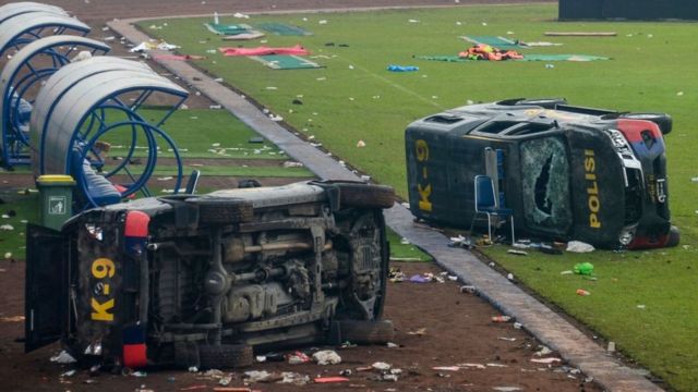 Damaged police vehicles were left on the field inside Kanjuruhan Stadium