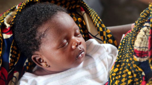 Un bébé dormant dans les bras de sa mère au Togo