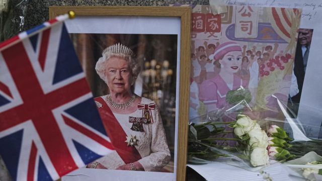 香港英國領事館外民眾擺放英女王伊麗莎白二世遺像與紀念她1975年訪問香港的繪畫（10/9/2022）